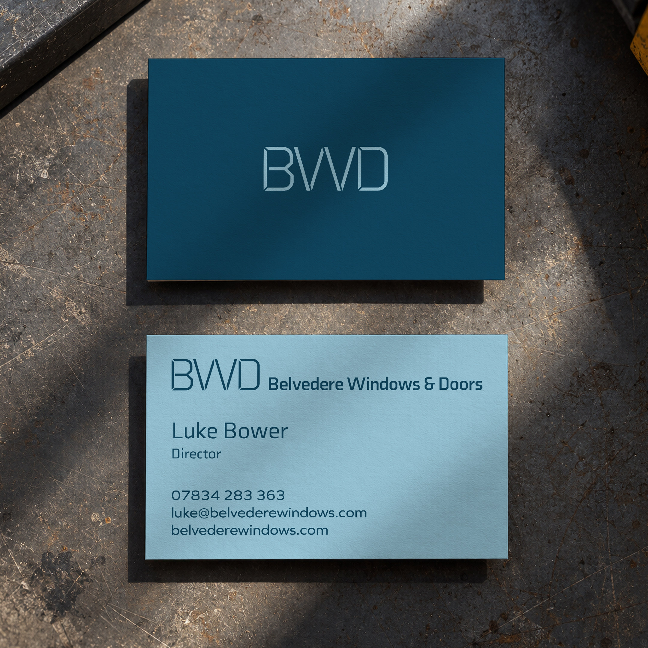Belvedere business cards, front and back, on a workshop bench