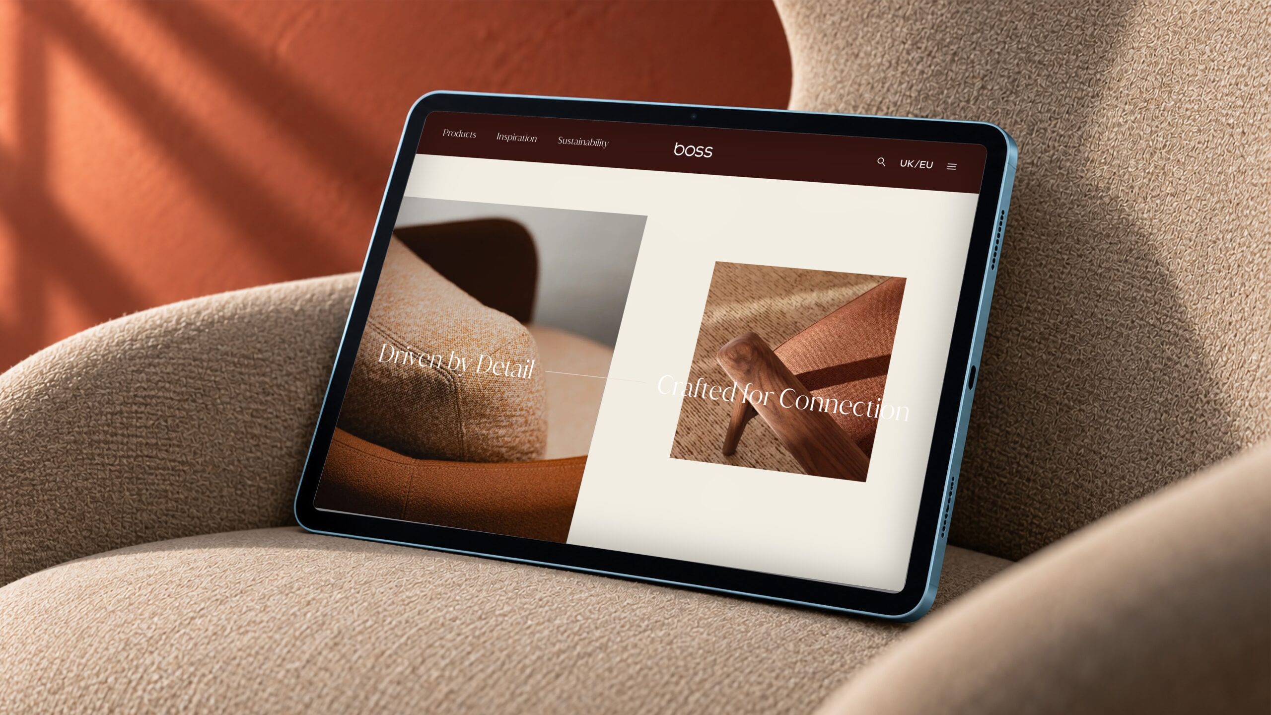 Boss Design website on a tablet propped against an armchair
