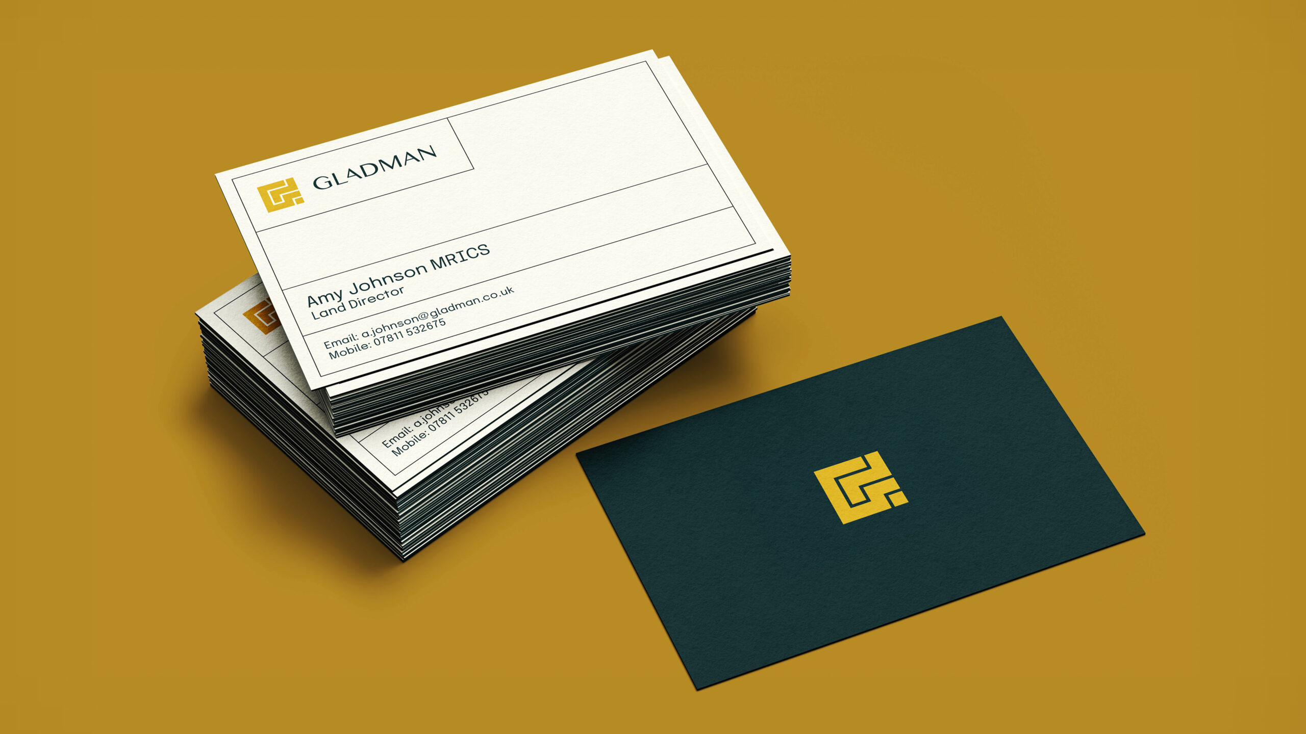 Gladman business cards in cream and dark teal on gold