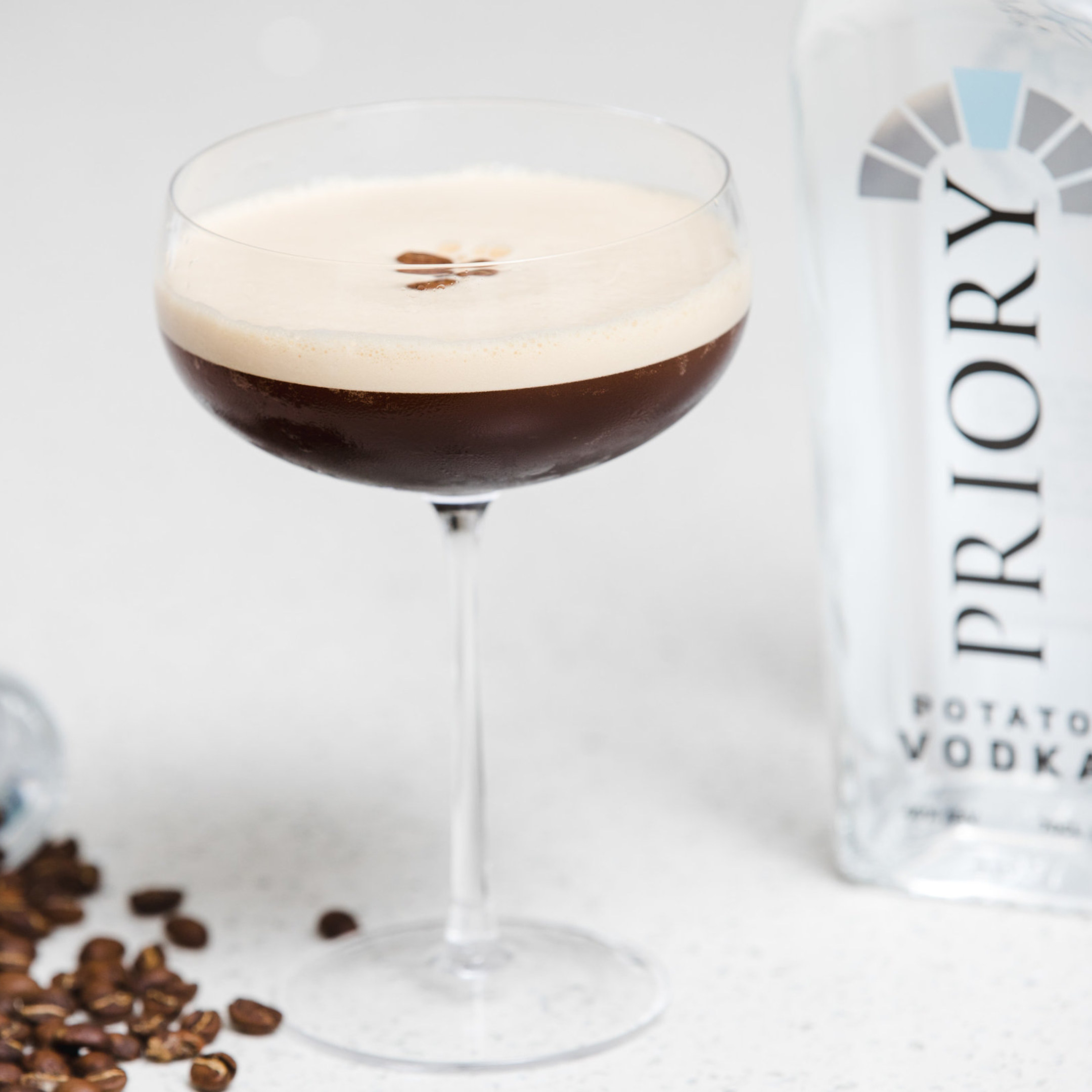 Espresso martini in front of a Priory Vodka bottle